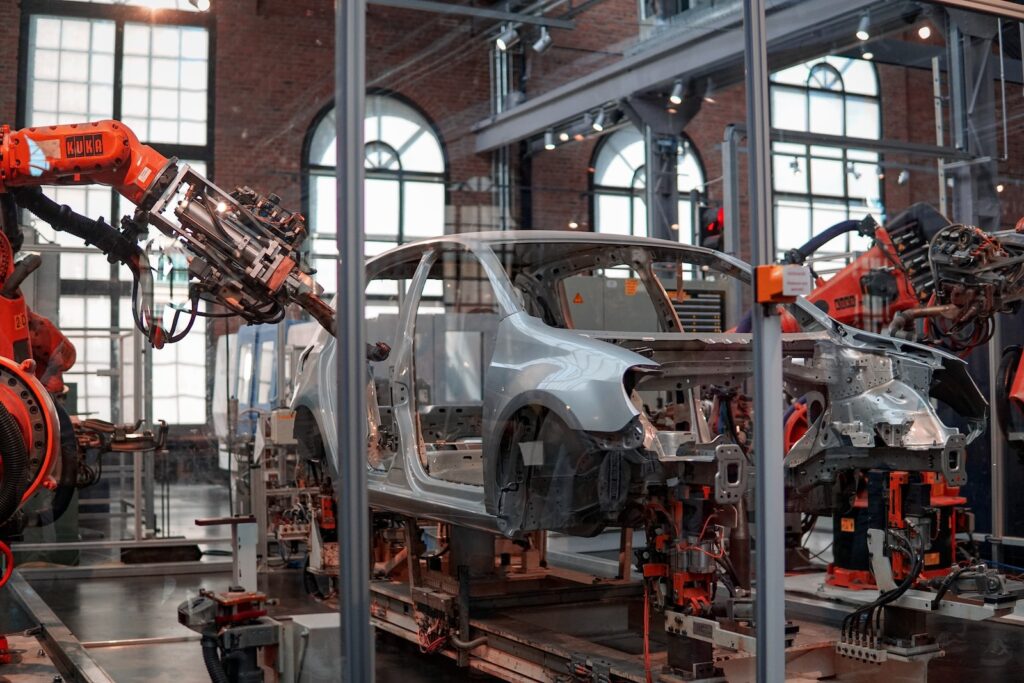gray vehicle being fixed inside factory using  robot machines Sztuczna inteligencja